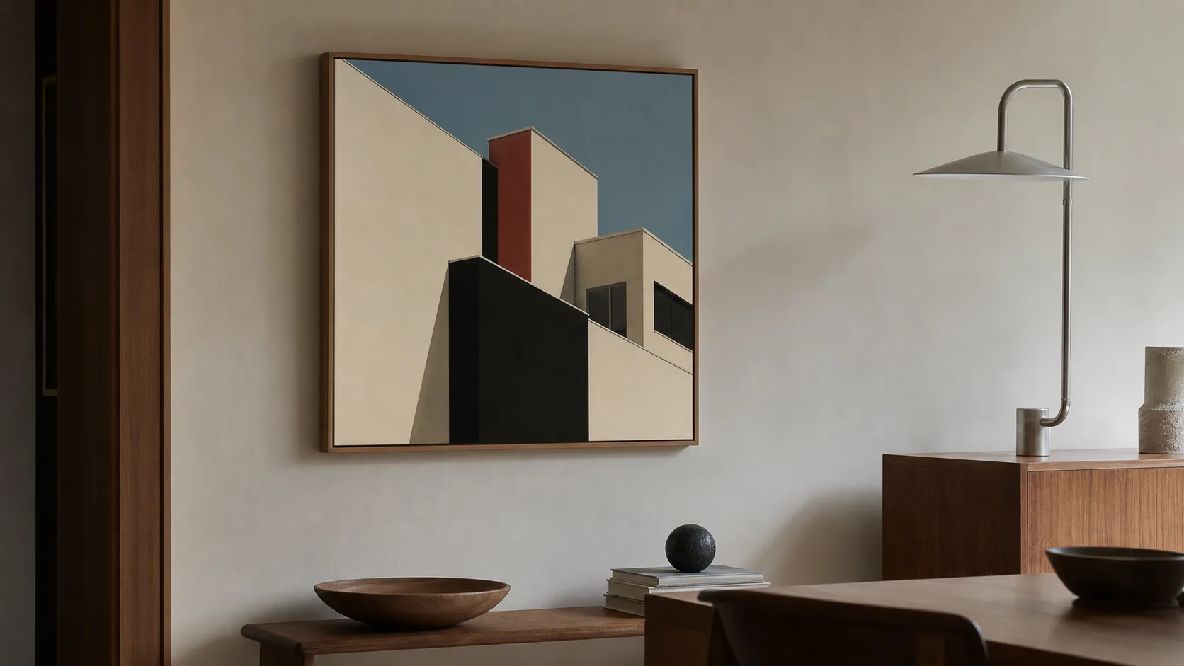 Geometriskt arkitekturinspirerat konstverk med svarta, krämvita, röda och blå fält i en återhållsam interiör