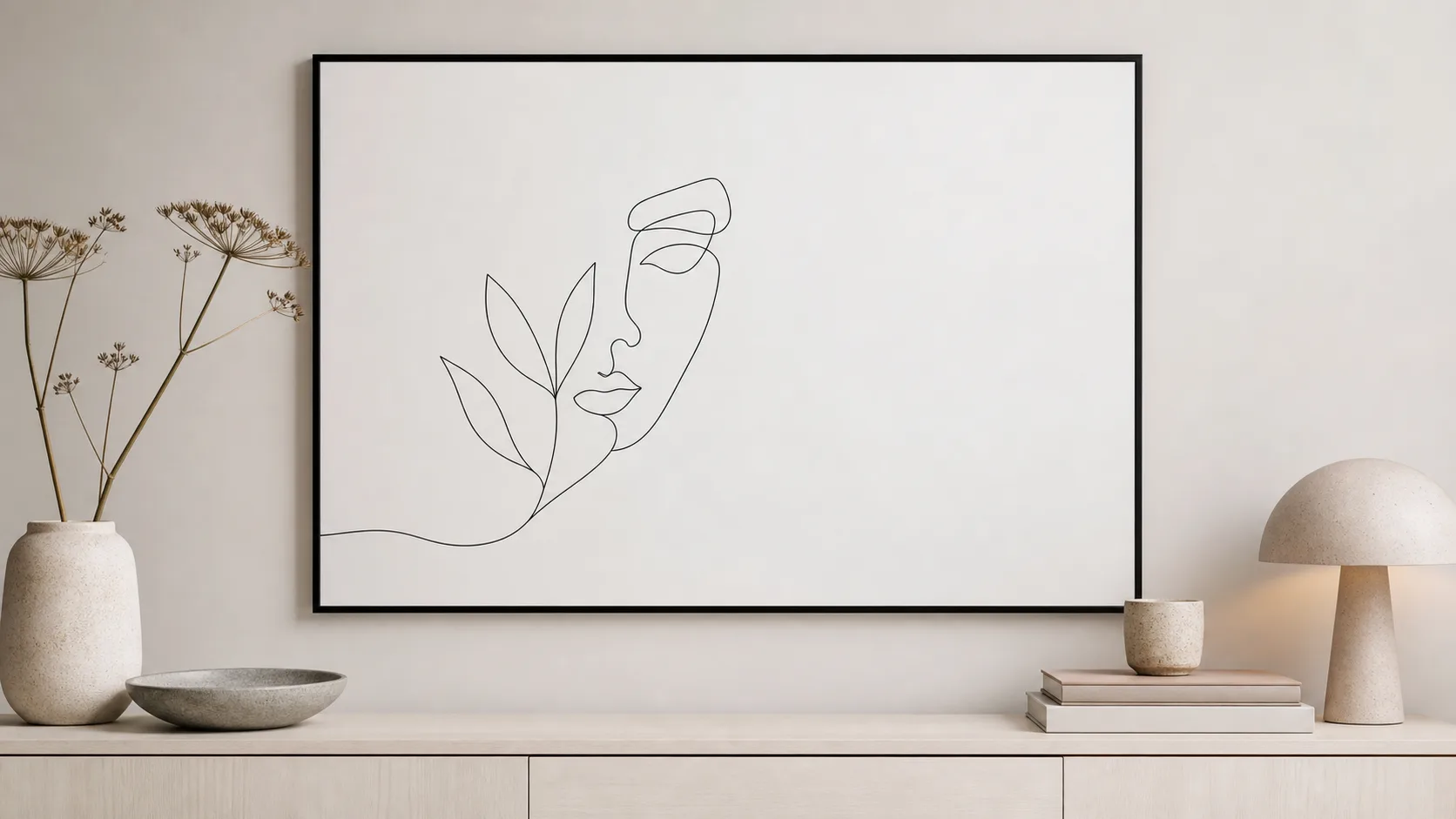 Stor vit line art-tavla med en sammanhängande mörk linje som bildar ett ansikte och blad i smal svart ram