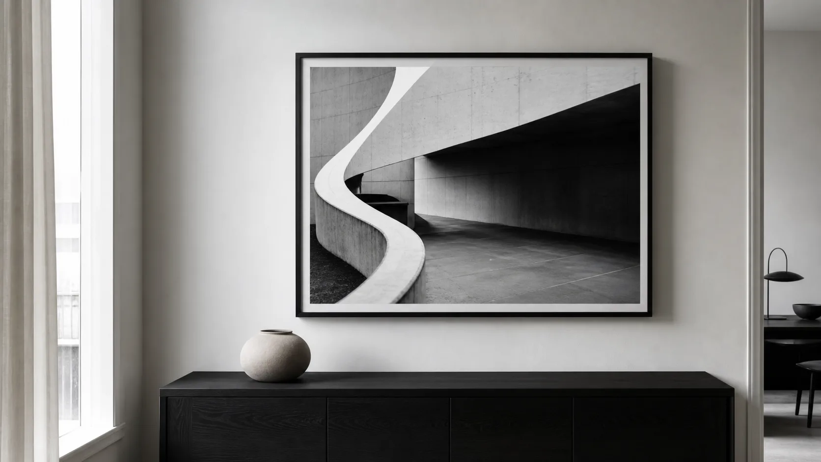 Svartvitt arkitekturfotografi med starka ljusa och mörka former i smal svart ram